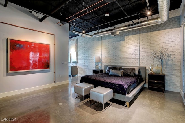 bedroom featuring concrete flooring and brick wall