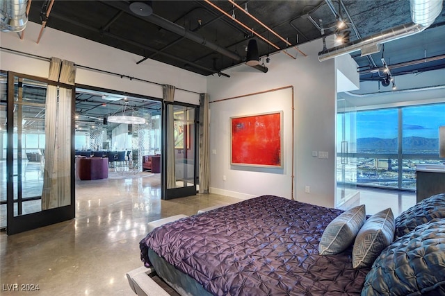 bedroom featuring concrete floors, a mountain view, and french doors