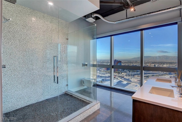 bathroom with toilet, vanity, concrete floors, and walk in shower