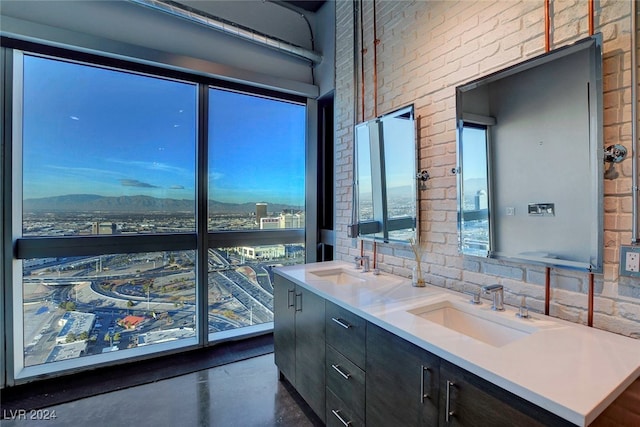 bathroom featuring vanity, concrete flooring, and brick wall