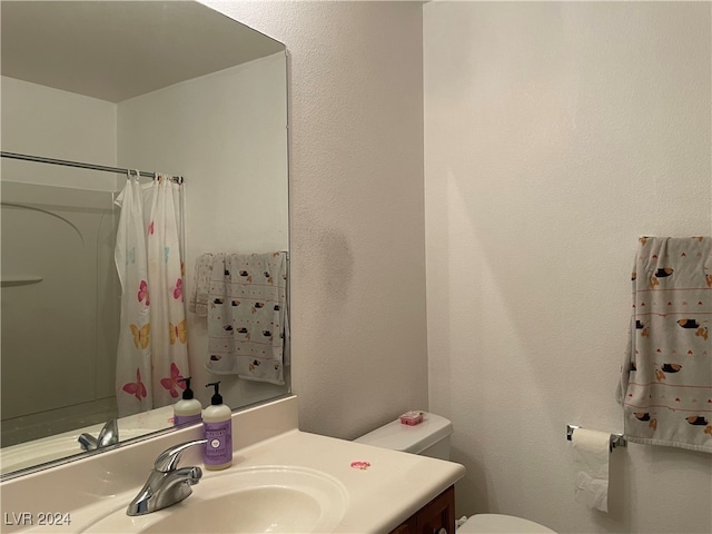 bathroom featuring a shower with curtain, vanity, and toilet