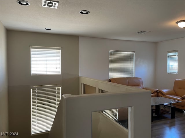 living room with a textured ceiling and dark wood-type flooring