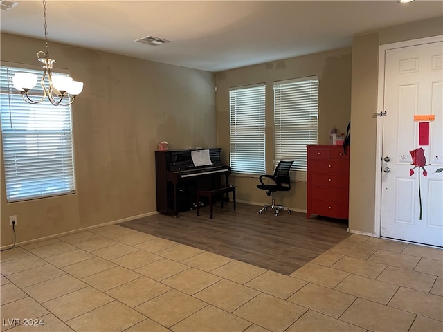 miscellaneous room featuring light wood-type flooring and an inviting chandelier