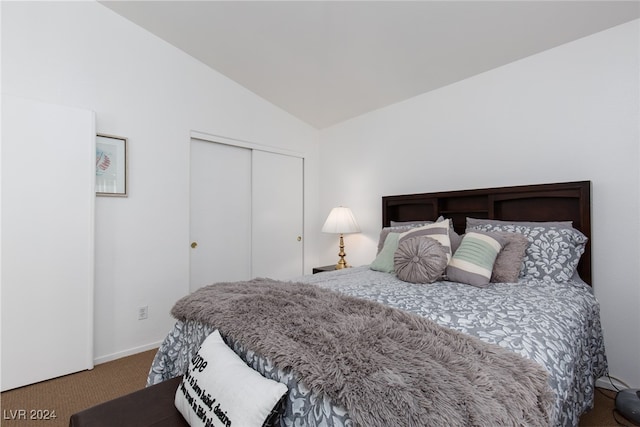 carpeted bedroom with a closet and lofted ceiling