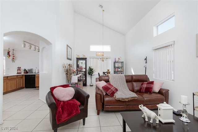 tiled living room featuring an inviting chandelier and high vaulted ceiling