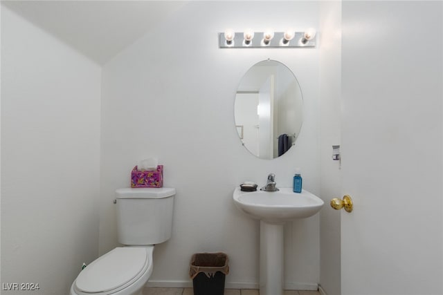 bathroom with tile patterned floors, vaulted ceiling, and toilet