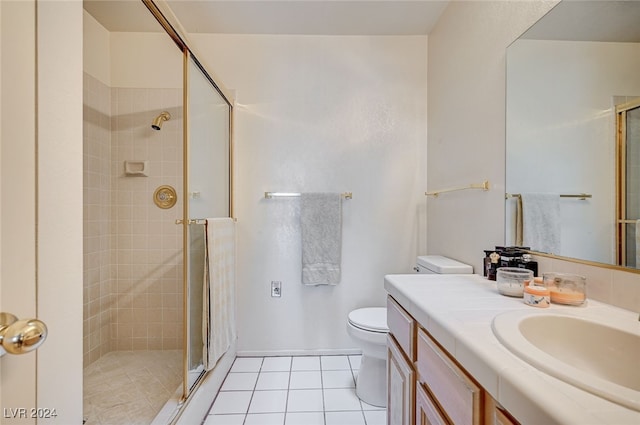 bathroom with vanity, toilet, tile patterned floors, and a shower with door