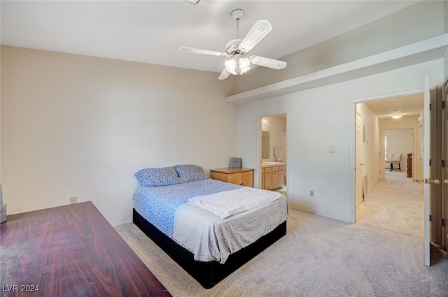 bedroom featuring connected bathroom, ceiling fan, and light carpet