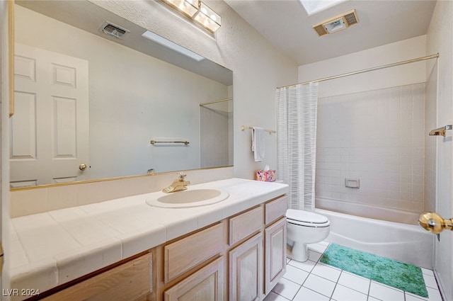 full bathroom with a skylight, tile patterned floors, vanity, shower / bathtub combination with curtain, and toilet