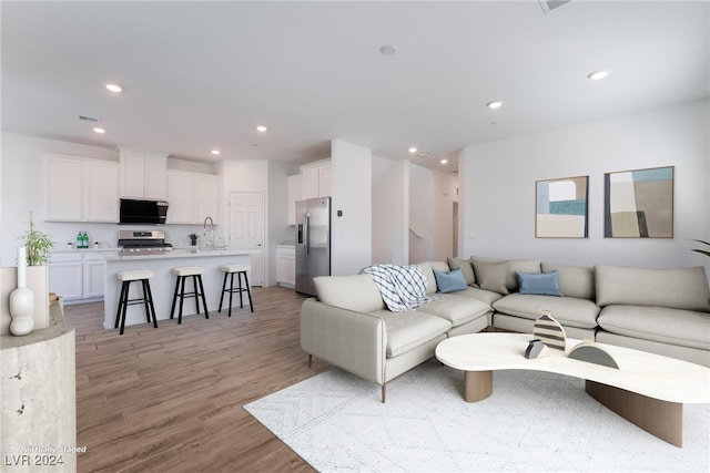 living room featuring sink and light wood-type flooring