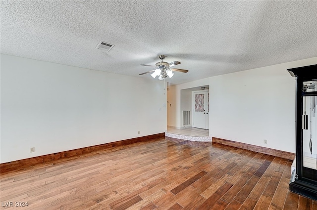 unfurnished living room with a textured ceiling, hardwood / wood-style flooring, and ceiling fan