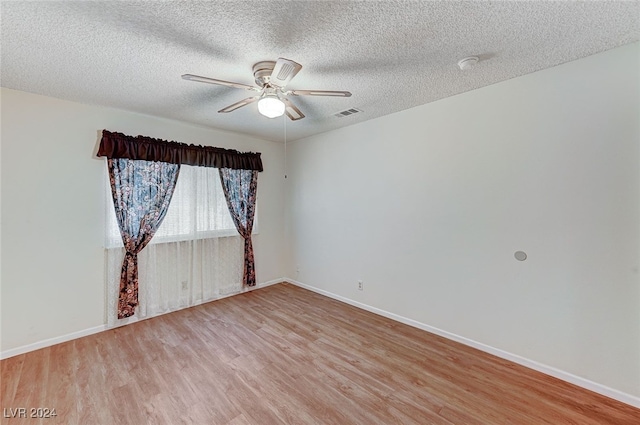 spare room with a textured ceiling, light hardwood / wood-style flooring, and ceiling fan