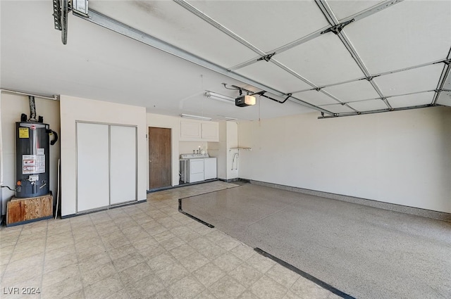 garage featuring independent washer and dryer, a garage door opener, and gas water heater