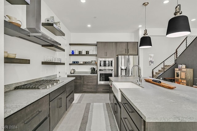 kitchen featuring sink, pendant lighting, appliances with stainless steel finishes, a large island with sink, and island range hood