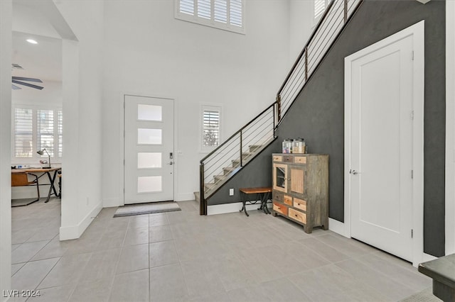 foyer entrance with a towering ceiling and light tile patterned flooring