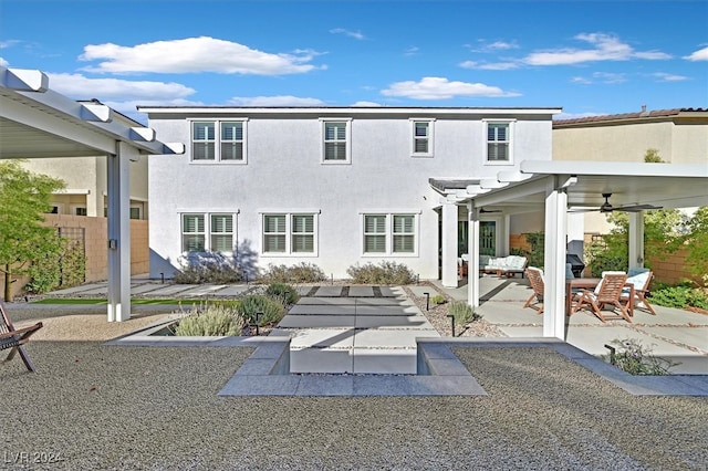 back of property with ceiling fan, a patio, and a pergola