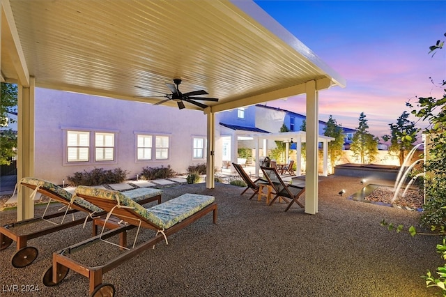 patio terrace at dusk with ceiling fan and an outdoor hangout area