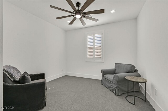 sitting room with ceiling fan and carpet flooring