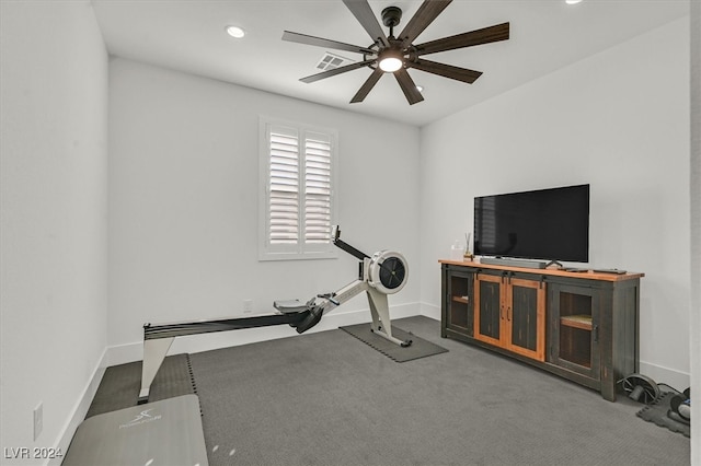 exercise room featuring dark carpet and ceiling fan