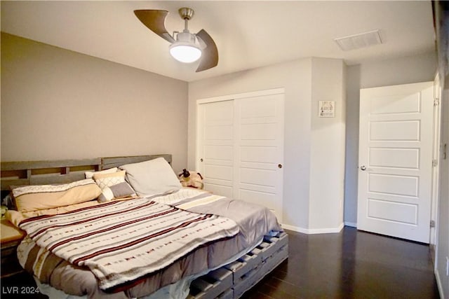 bedroom featuring ceiling fan, dark hardwood / wood-style flooring, and a closet