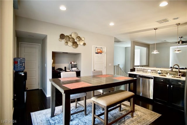 kitchen with dishwasher, sink, decorative light fixtures, dark hardwood / wood-style flooring, and kitchen peninsula