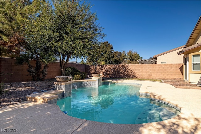 view of pool with pool water feature and a patio