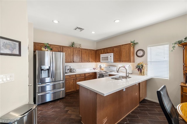 kitchen featuring kitchen peninsula, white appliances, and sink