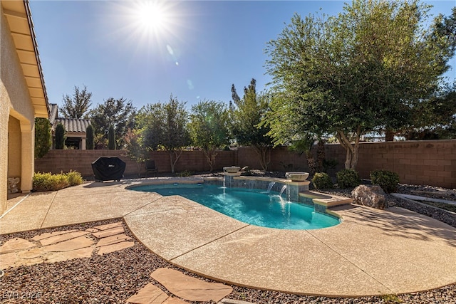 view of swimming pool with pool water feature and a patio