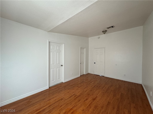 unfurnished room featuring wood-type flooring and a textured ceiling