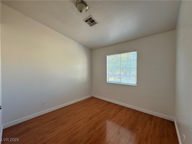 spare room with wood-type flooring and a textured ceiling