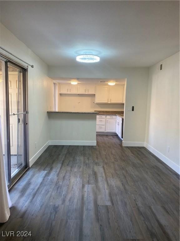 5317 Indian River Dr Unit 295, Las Vegas, NV 89103 - unfurnished living room with baseboards and dark wood-style flooring