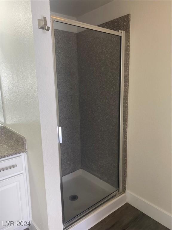 5317 Indian River Dr Unit 295, Las Vegas, NV 89103 - bathroom with a stall shower, wood finished floors, and baseboards