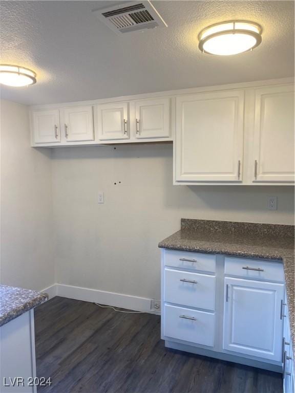 5317 Indian River Dr Unit 295, Las Vegas, NV 89103 - laundry room with dark wood-type flooring, baseboards, and a textured ceiling