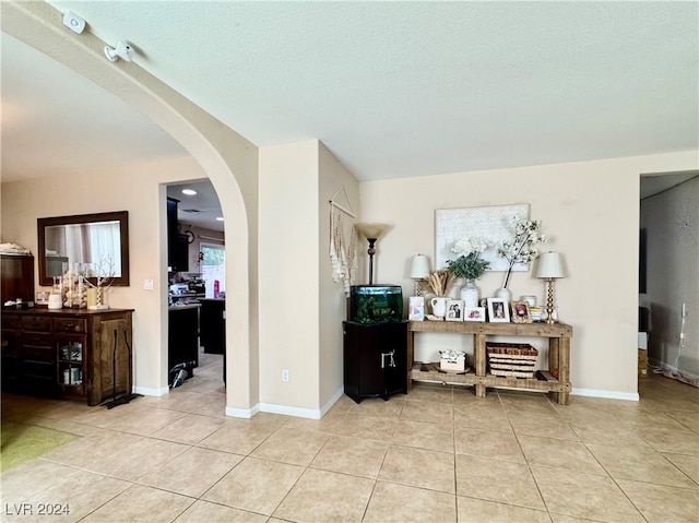 interior space featuring light tile patterned floors and a textured ceiling