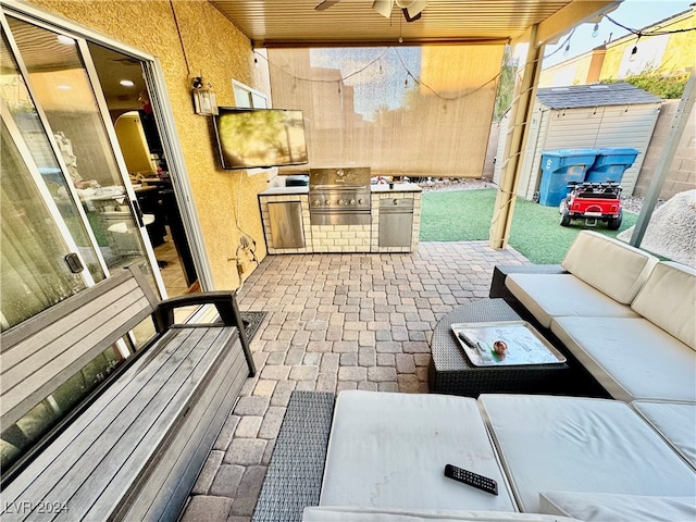 view of patio / terrace with an outdoor living space, ceiling fan, and exterior kitchen