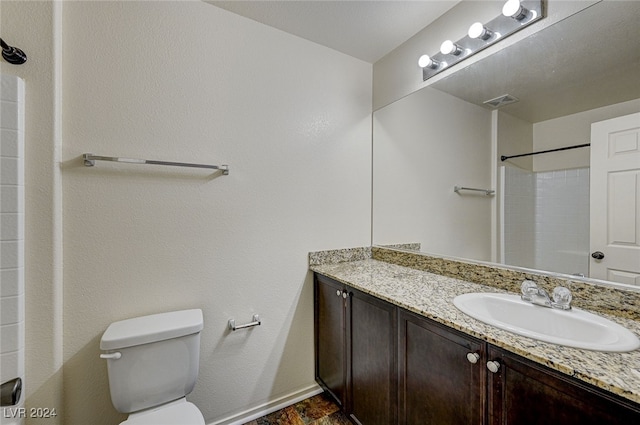 bathroom with vanity, toilet, and walk in shower