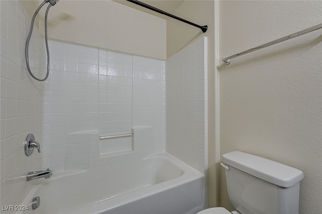 bathroom with toilet and tiled shower / bath