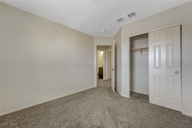 unfurnished bedroom featuring carpet flooring and a closet