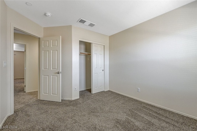 unfurnished bedroom featuring carpet and a closet