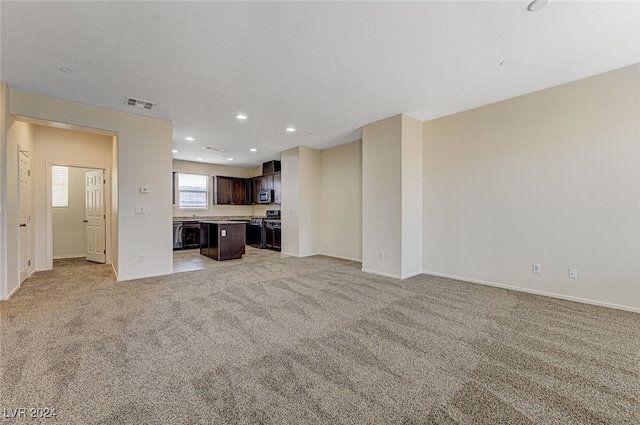 unfurnished living room featuring light colored carpet