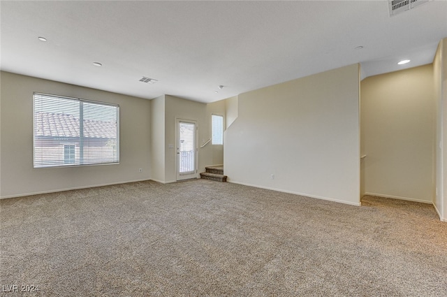 spare room featuring light colored carpet