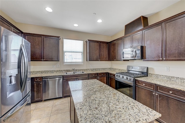 kitchen with appliances with stainless steel finishes, dark brown cabinetry, and light tile patterned floors