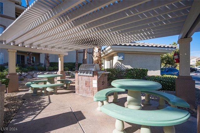 view of patio featuring a pergola, exterior kitchen, and grilling area