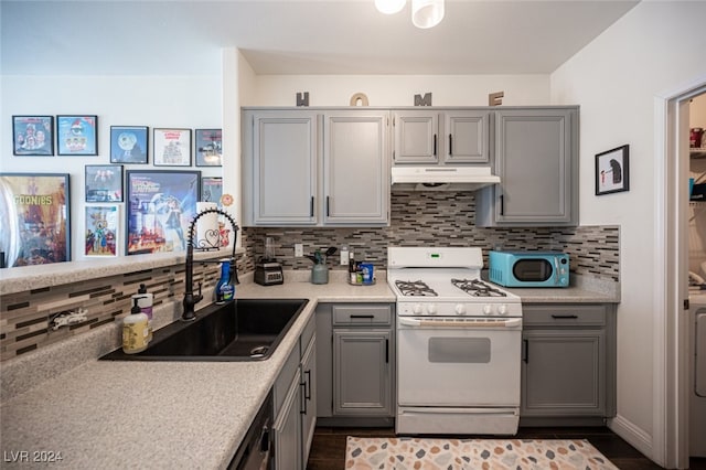 kitchen featuring backsplash, gray cabinets, white appliances, and sink