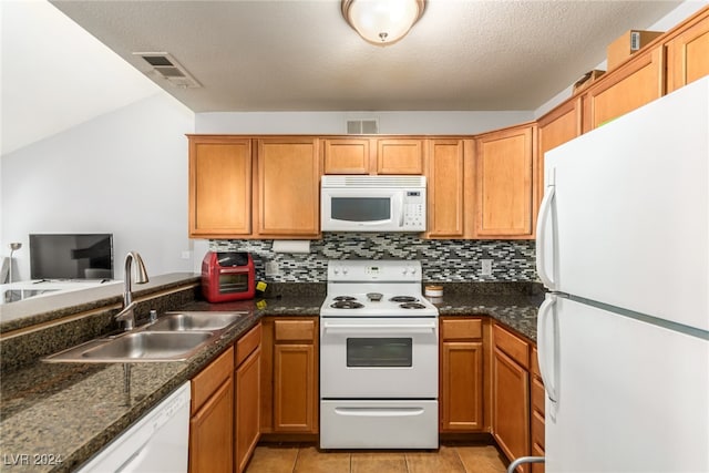kitchen with white appliances, sink, light tile patterned floors, a textured ceiling, and tasteful backsplash
