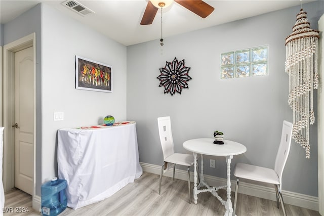 dining area with light wood-type flooring and ceiling fan