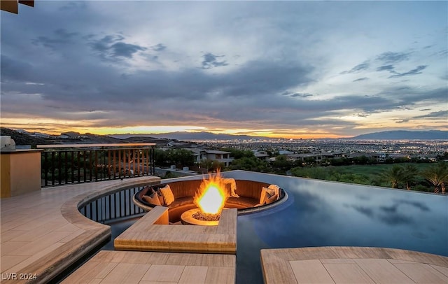 patio terrace at dusk with a mountain view and a fire pit