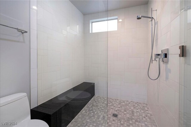 bathroom featuring toilet and a tile shower