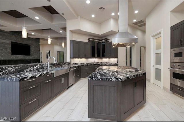 kitchen featuring sink, appliances with stainless steel finishes, dark stone countertops, a spacious island, and decorative light fixtures