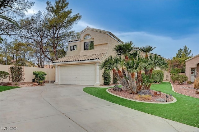 mediterranean / spanish-style home featuring a front yard and a garage